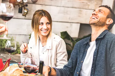 Freunde sitzen zusammen und lachen und feiern gemeinsam - Magenbrennen vorbeugen