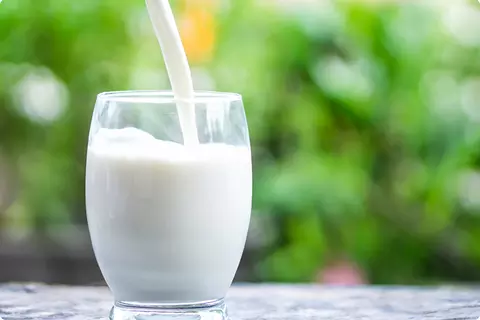 Un verre de lait est versé - remède maison contre les brûlures d'estomac