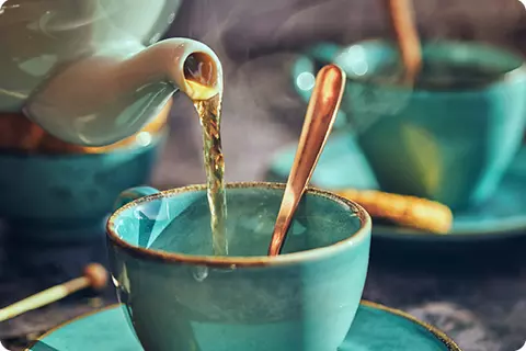 Une tasse de thé est versée - Boire suffisamment peut prévenir les brûlures d'estomac