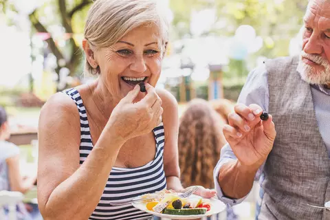 Zwei ältere Personen fröhlich beim Essen - kein Magenbrennen mit Refluctan