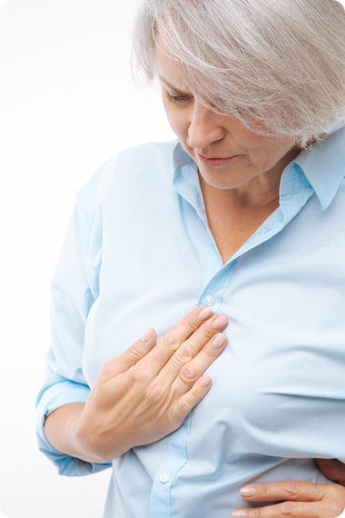 Ältere Frau hält sich eine Hand an die Brust - Reflux - Magenbrennen