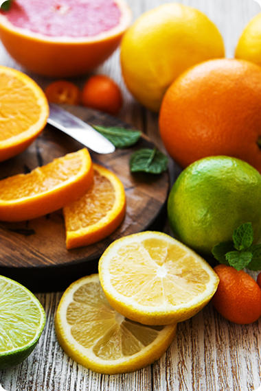 Verschiedene aufgeschnittene und ganze säurehältige Früchte - Orangen, Zitronen, Limonen - Magenbrennen und Ernährung
